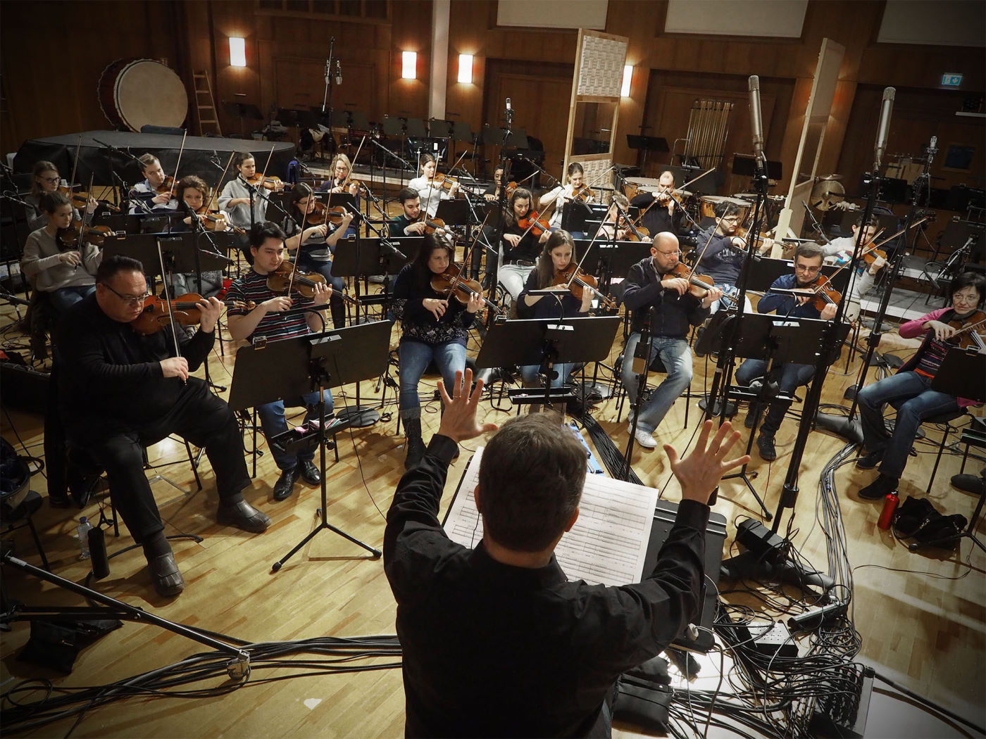 Multiple large metal sheet percussion instruments, possibly thunder sheets or gongs, arranged on stands in a recording studio or concert hall.