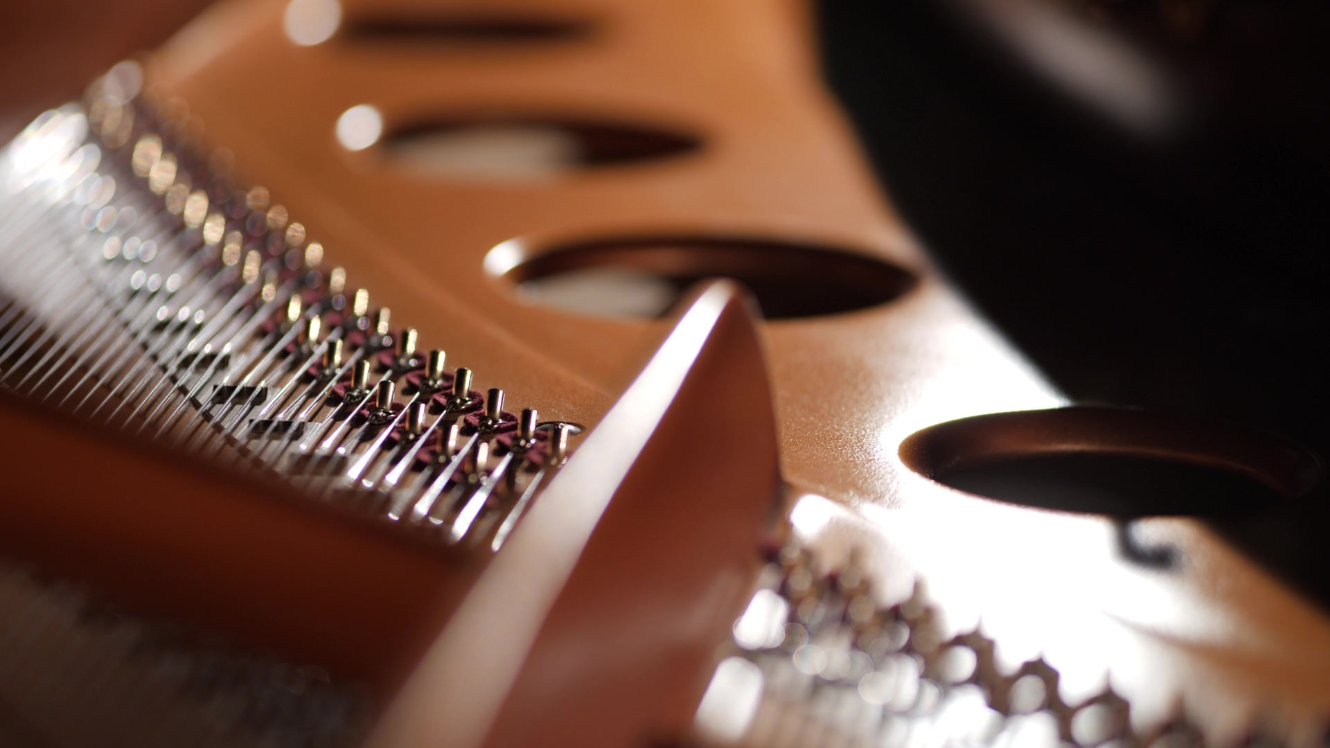 Close-up of the internal strings and tuning pins of a Bösendorfer 280VC Vienna Concert grand piano, showcasing fine craftsmanship.