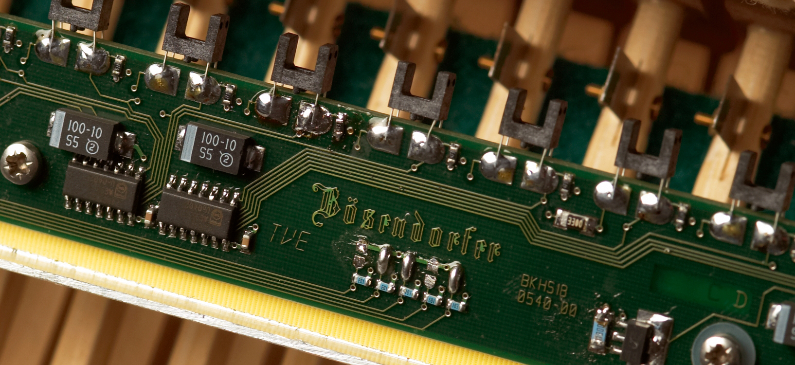 Close-up of a green Studio Bösendorfer Imperial piano circuit board with microchips, transistors, and clearly visible Bösendorfer branding.