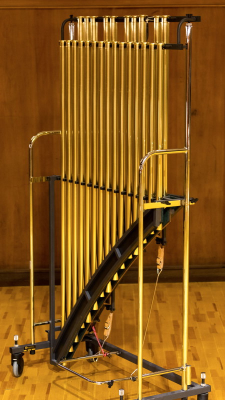 Musical instrument tubular bells with brass tubes on a dark background.