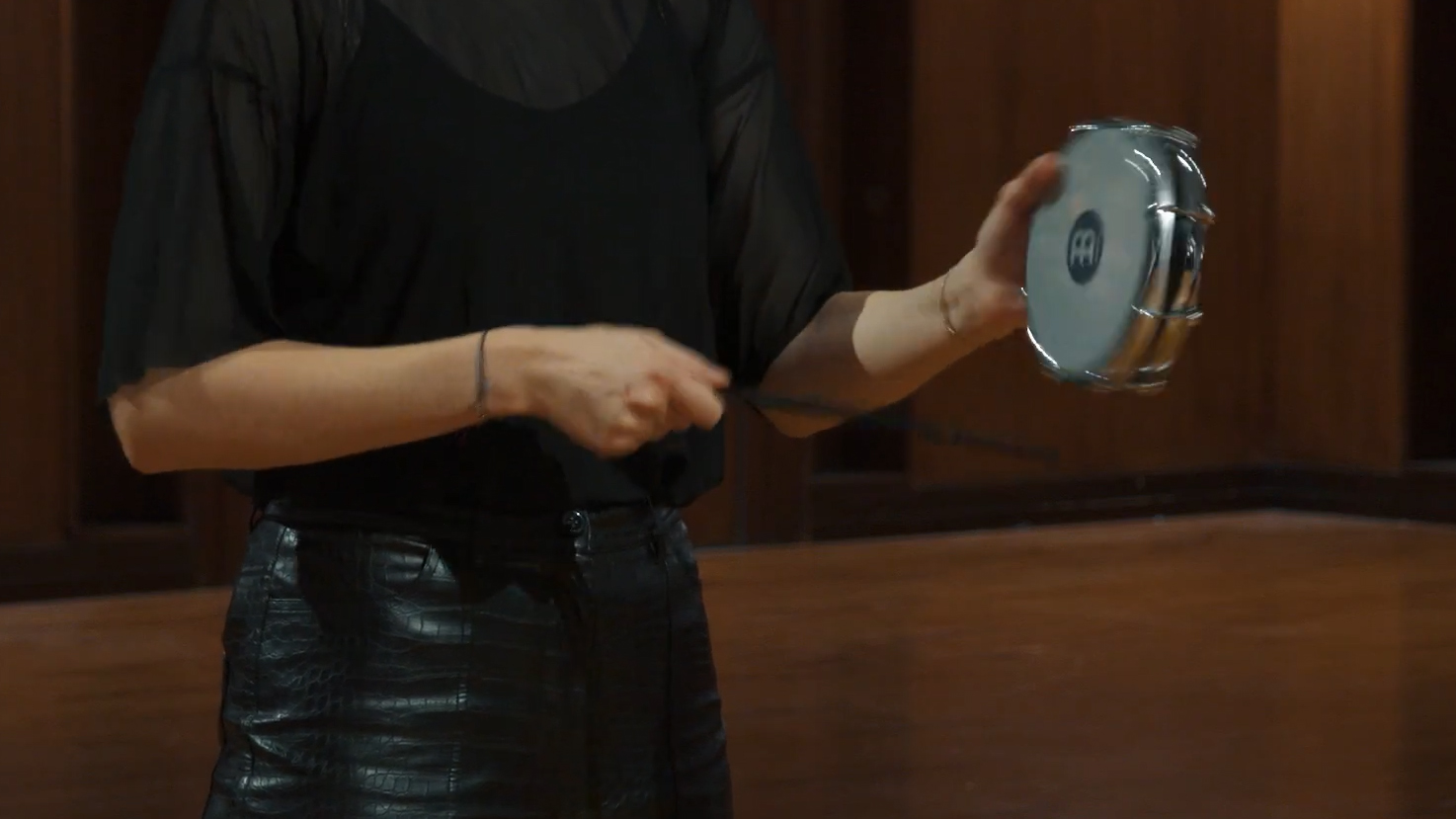 Person playing a Meinl Percussion tambourine with a drumstick