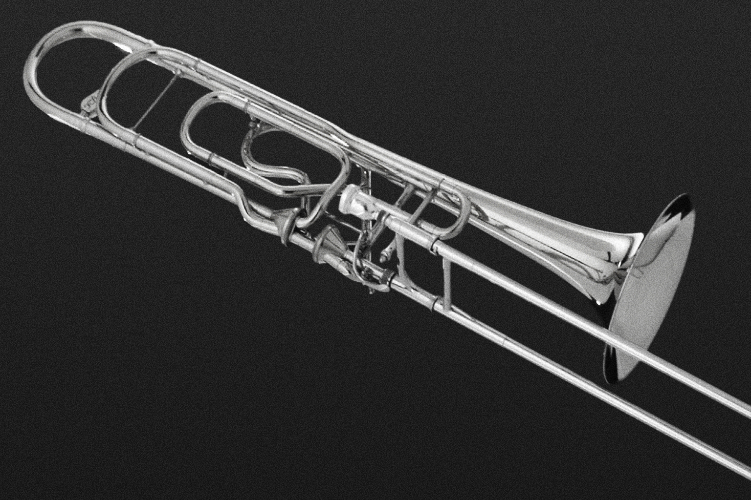 Silver trombone against a dark background, showcasing its polished metal and intricate tubing, musical instrument, brass instrument.