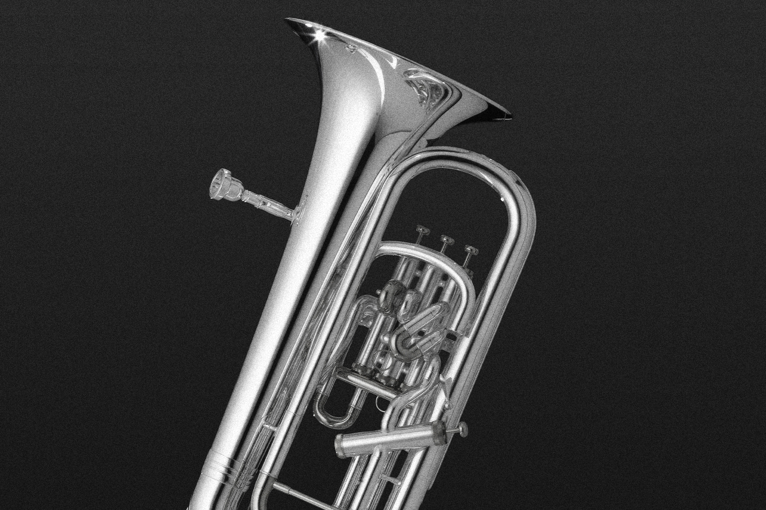 Silver euphonium musical instrument with a black background, showcasing its valves, tubing, and bell, emphasizing its polished metallic surface and intricate details.